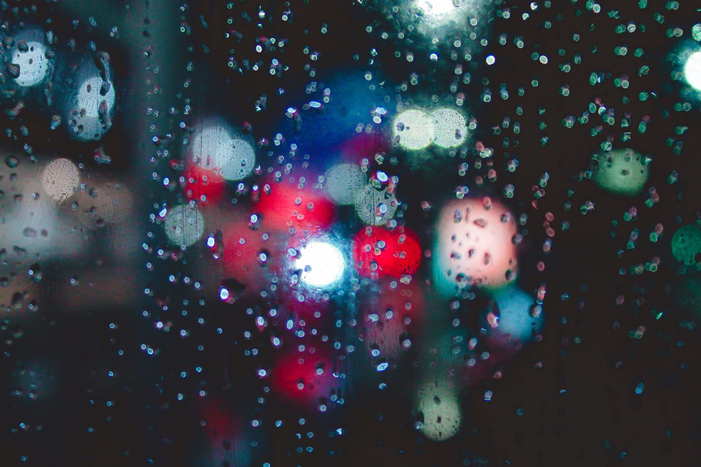 Raindrops on a window with blurred London lights at night