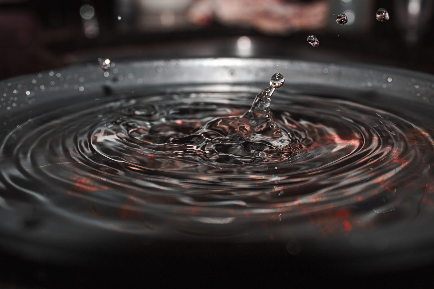 Drips falling into a bucket of water in low light